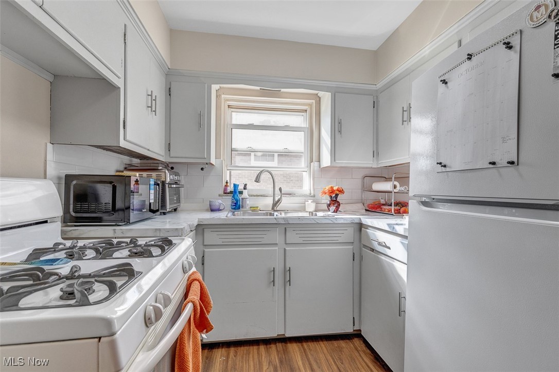 6136 Ridge Road Cleveland, OH 44129 - Photo 24 of 40 Kitchen with white appliances, light countertops, decorative backsplash, and light wood-style floors