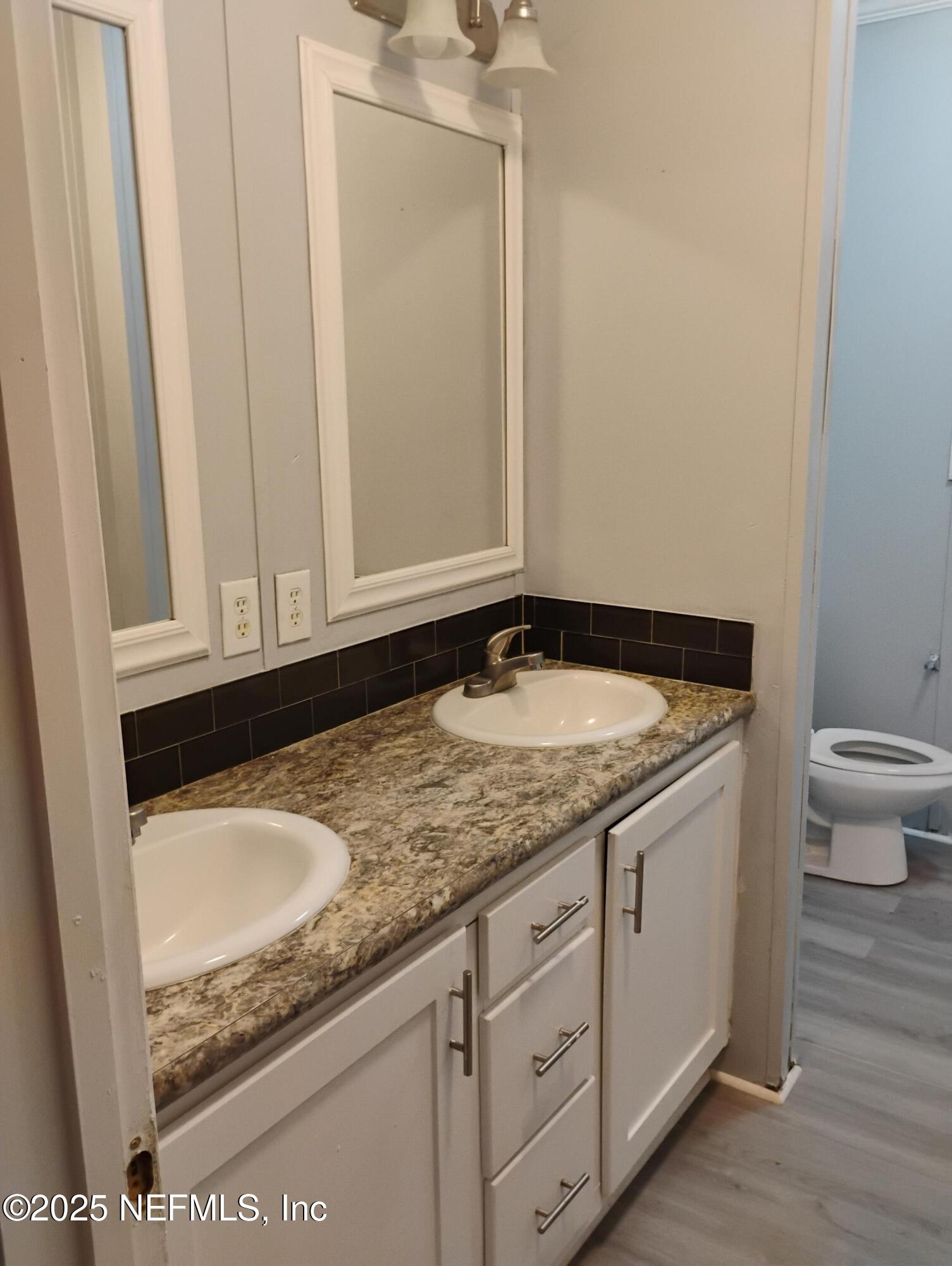 598 San Mateo Road San Mateo, FL 32187 - Photo 13 of 14 a bathroom with a granite countertop sink and a toilet
