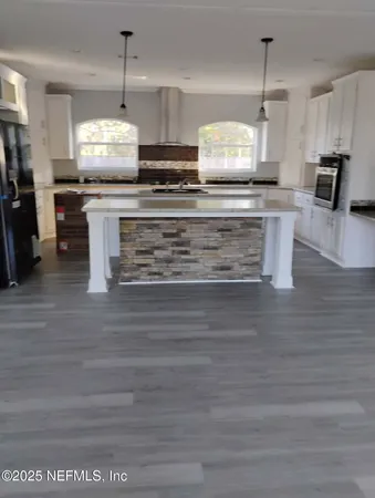 a kitchen with stainless steel appliances kitchen island granite countertop a stove a sink and a microwave