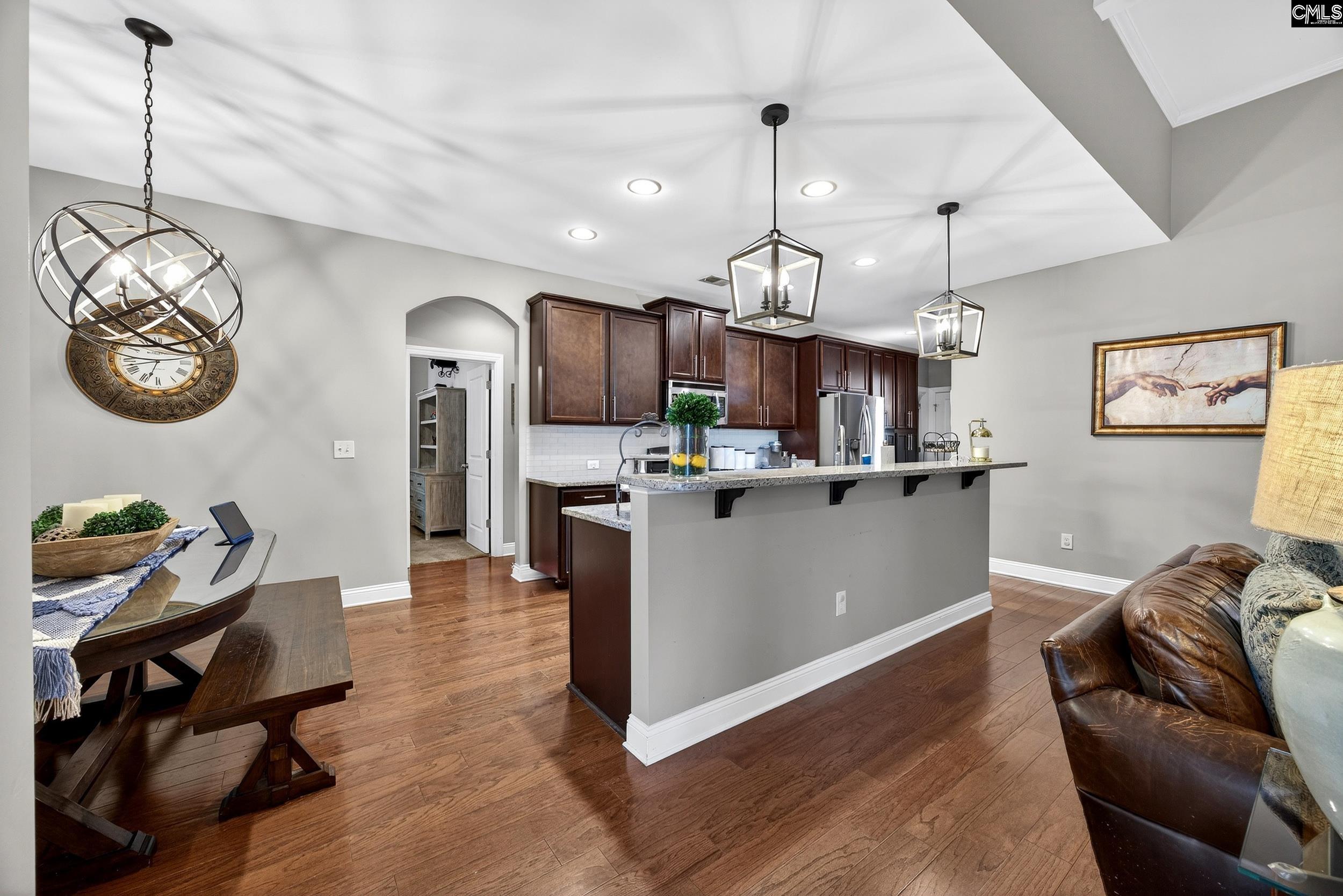116 Renard Way Gilbert, SC 29054 - Photo 21 of 74 a kitchen with stainless steel appliances kitchen island granite countertop a rug a stove a sink a dining table and chairs