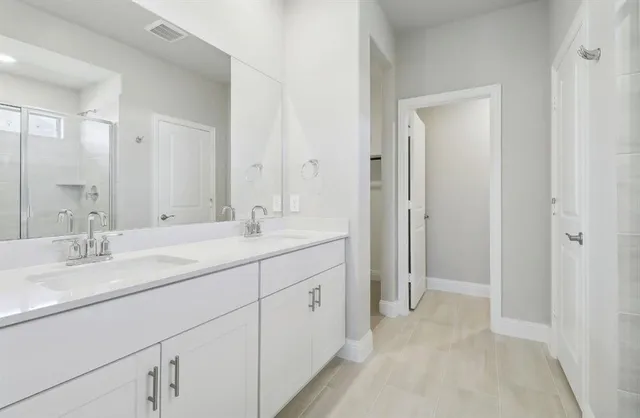 a bathroom with double vanity sink and a mirror