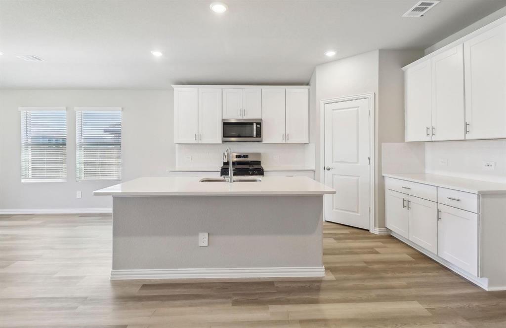 503 Stagg Street McKinney, TX 75069 - Photo 5 of 19 a kitchen with sink a microwave and cabinets