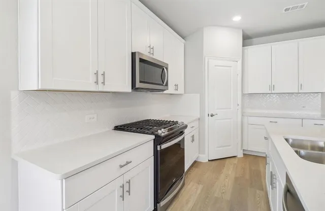 a kitchen that has a sink and a stove in it