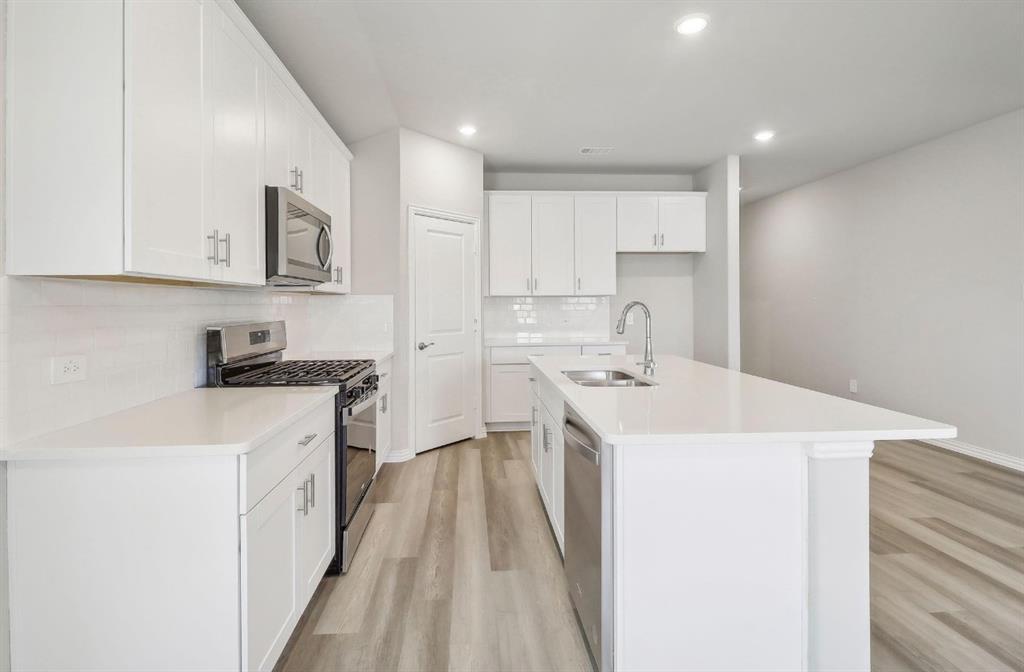 503 Stagg Street McKinney, TX 75069 - Photo 8 of 19 a kitchen that has a sink and a stove in it