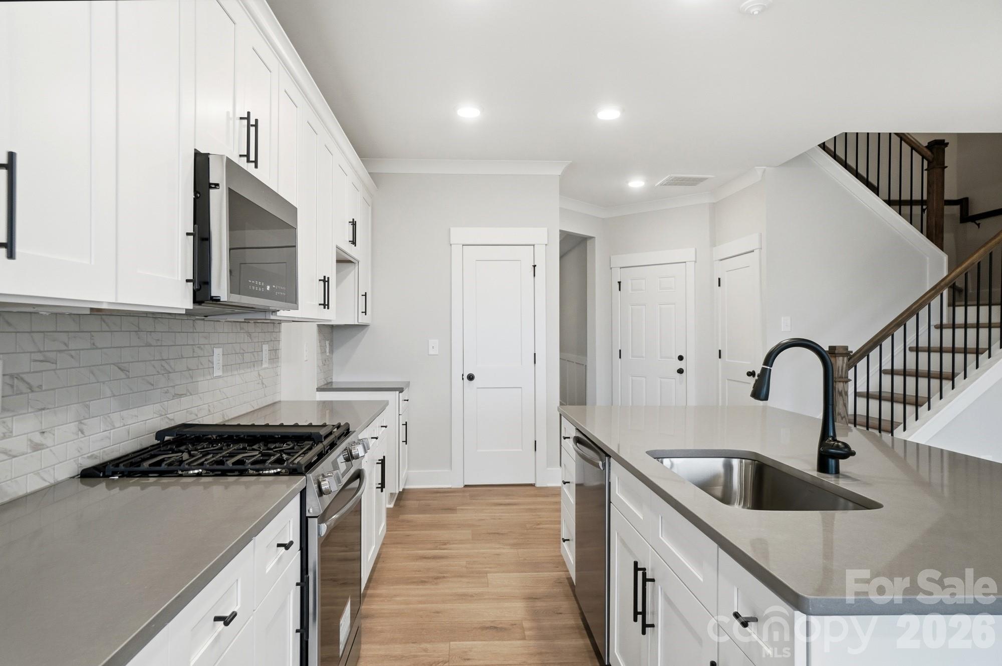 410 Limelight Road Waxhaw, NC 28173 - Photo 7 of 27 a kitchen with stainless steel appliances granite countertop a sink stove and refrigerator