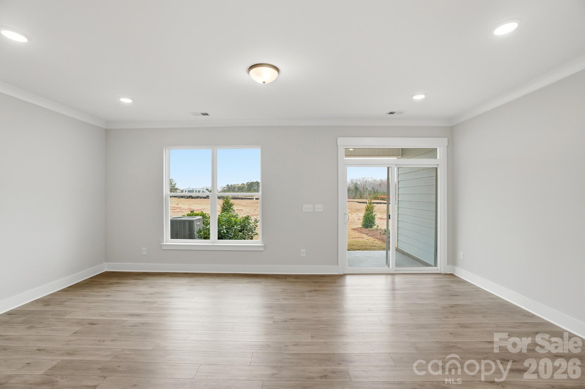 410 Limelight Road Waxhaw, NC 28173 - Photo 10 of 27 an empty room with wooden floor and windows