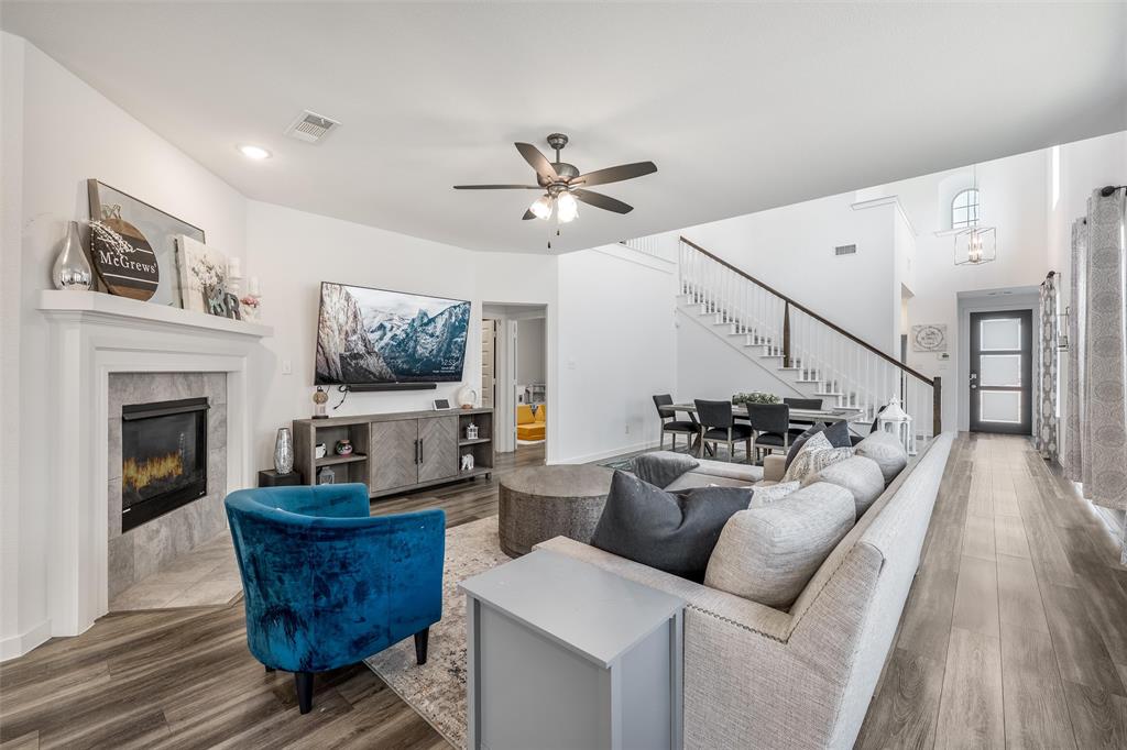 a living room with furniture a fireplace and wooden floor