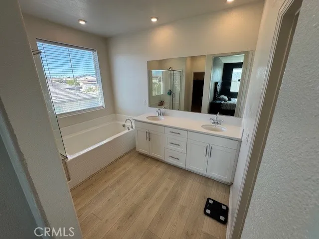 a bathroom with a sink a large mirror and a bathtub