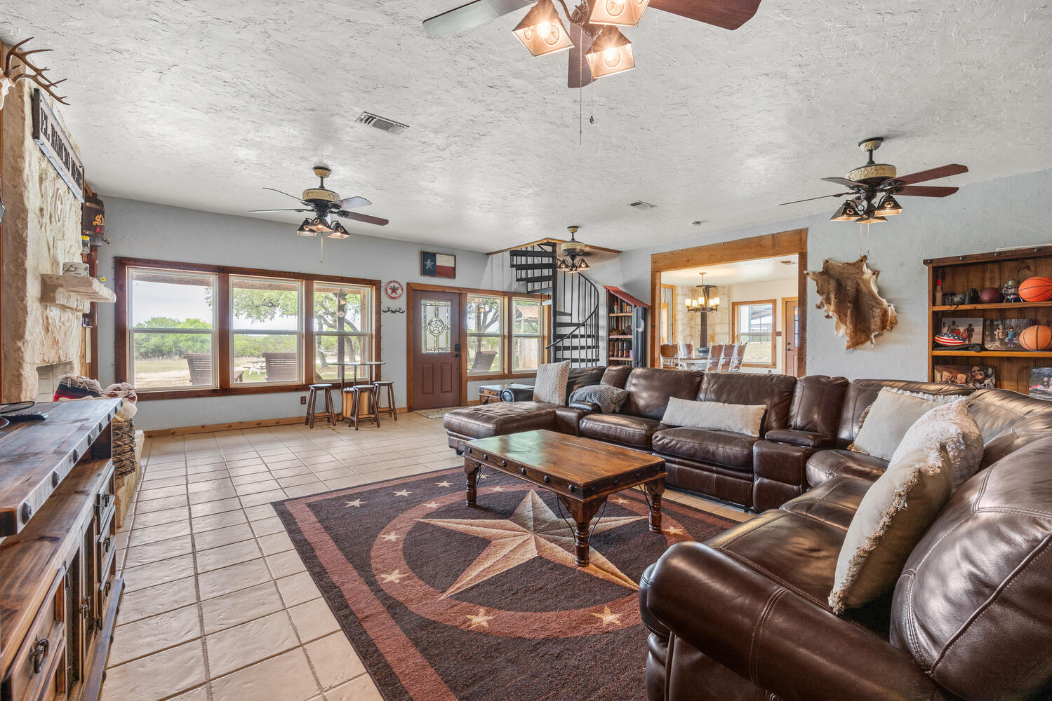 3487 Rust Spring Branch, TX 78070 - Photo 6 of 40 Spacious family room featuring tile floors, ceiling fans, a wealth of natural light, a pass-through fireplace, and a dart board!