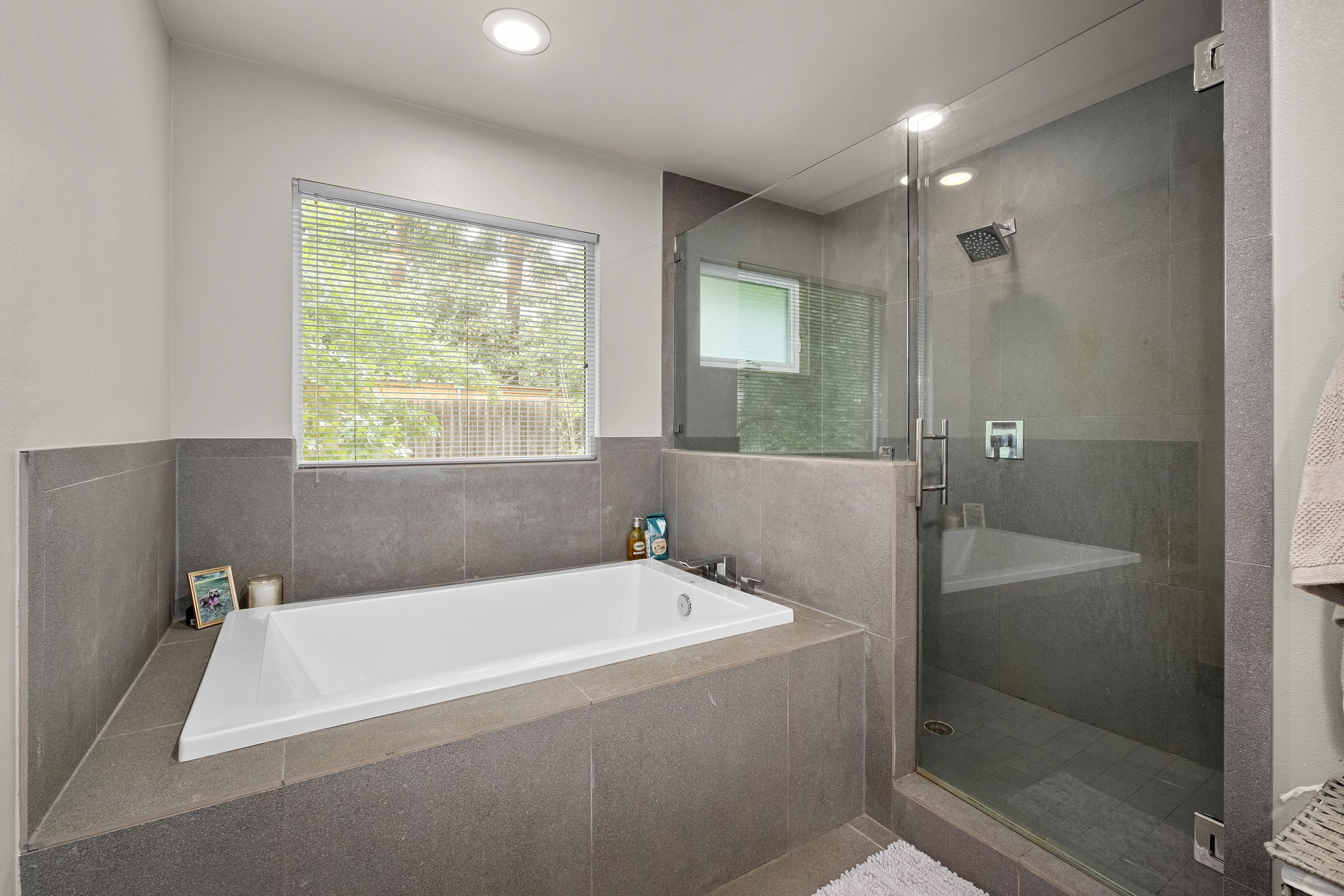 2802 Warren Street, Unit B Austin, TX 78703 - Photo 12 of 23 Bathroom featuring a built-in soaking tub and a glass-enclosed shower with a rainfall showerhead