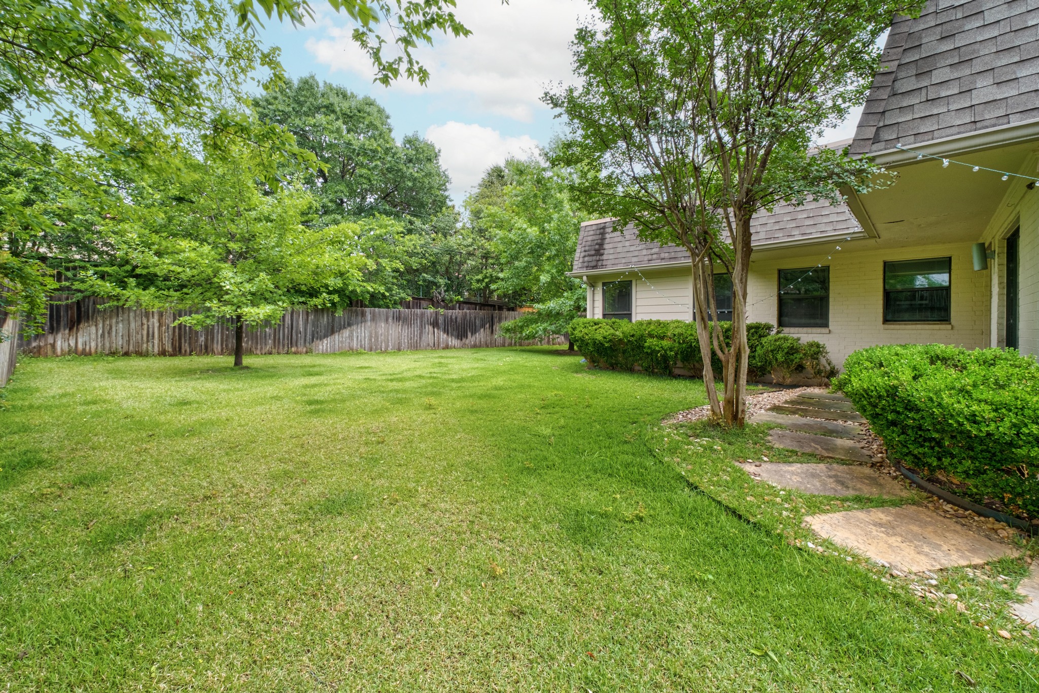 2802 Warren Street, Unit B Austin, TX 78703 - Photo 19 of 23 Expansive green lawn with mature trees and a wood privacy fence