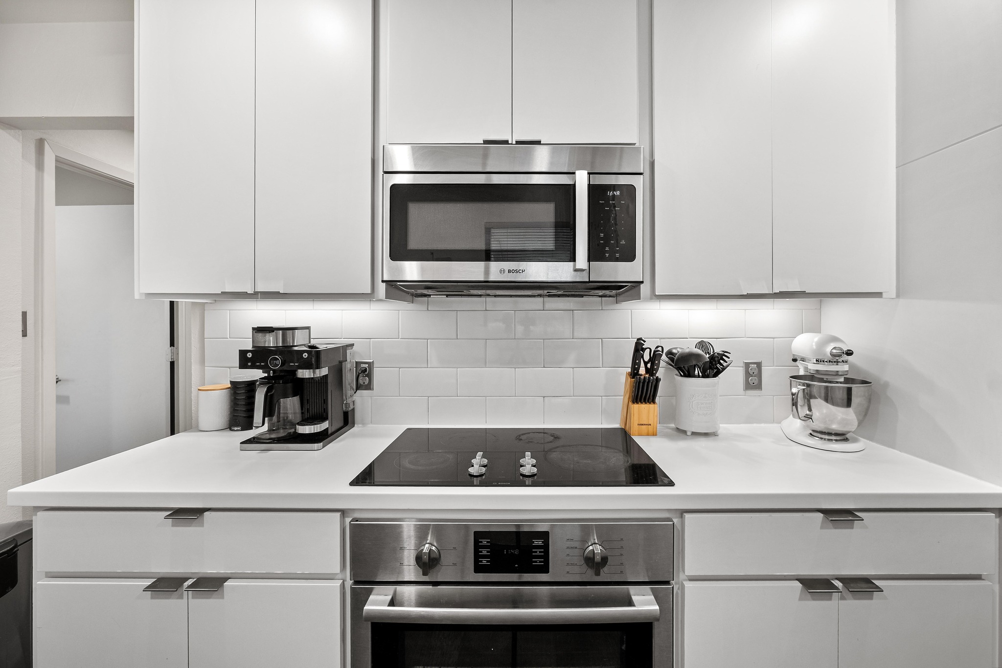 2802 Warren Street, Unit B Austin, TX 78703 - Photo 8 of 23 Contemporary kitchen with white cabinetry, stainless steel appliances, a built-in microwave, and an electric cooktop