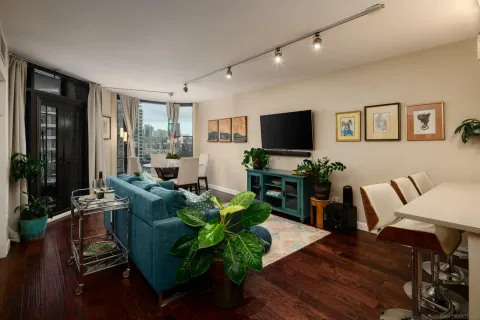 a living room with furniture flat screen tv and wooden floor