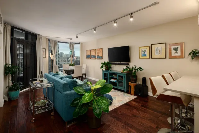 a living room with furniture flat screen tv and wooden floor