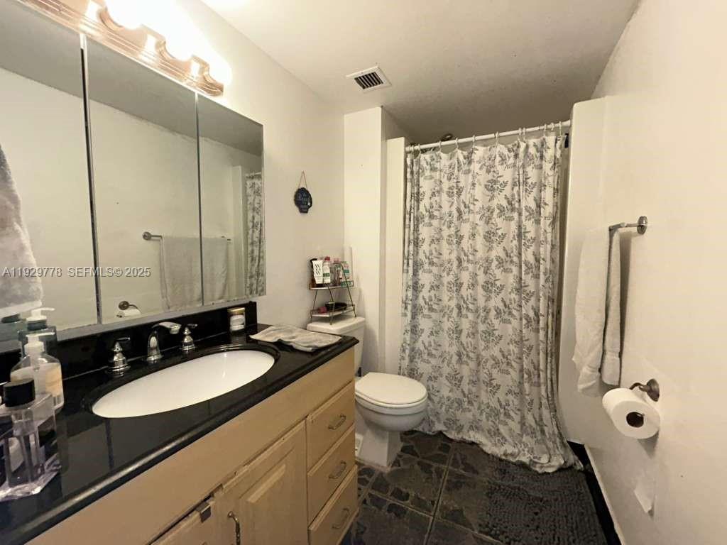 13499 Biscayne Boulevard, Unit 1206 North Miami, FL 33181 - Photo 11 of 20 a bathroom with a sink a toilet a mirror and shower