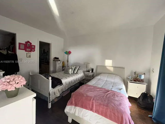 a bedroom with two beds and closet