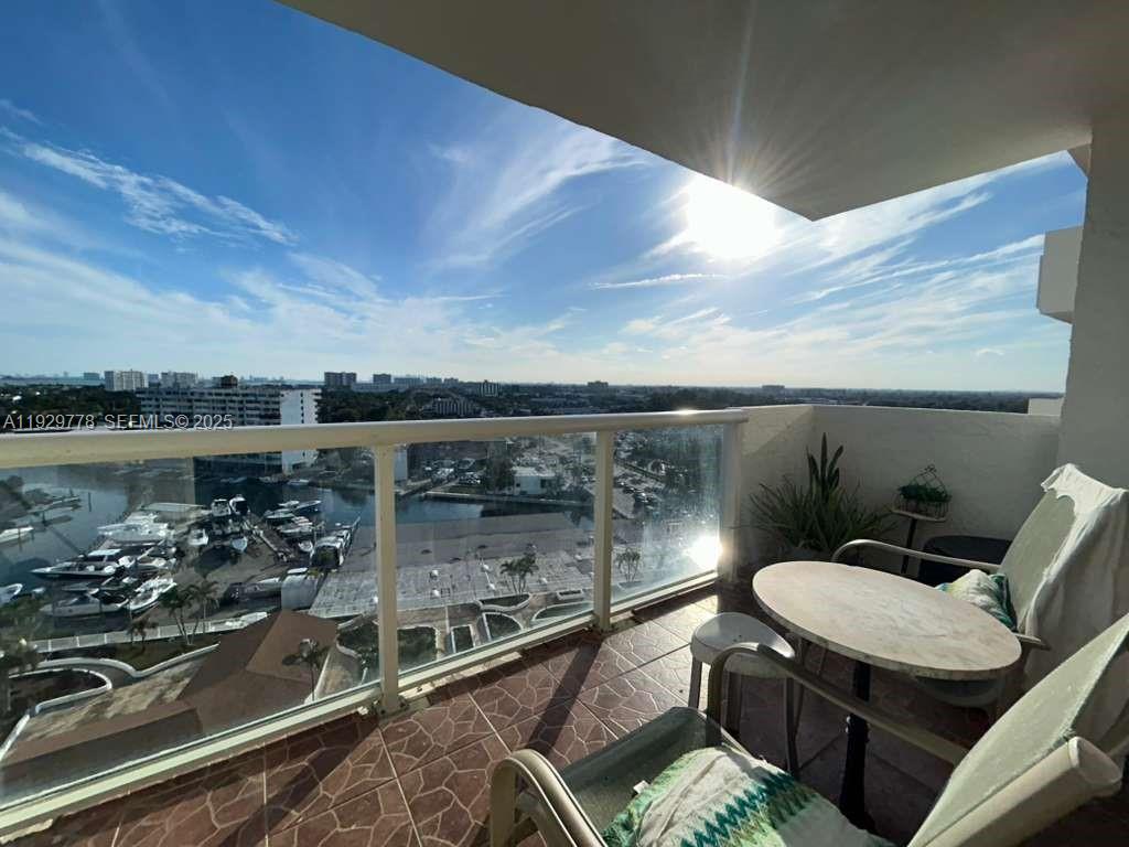 13499 Biscayne Boulevard, Unit 1206 North Miami, FL 33181 - Photo 14 of 20 a view of a balcony with chairs and wooden floor