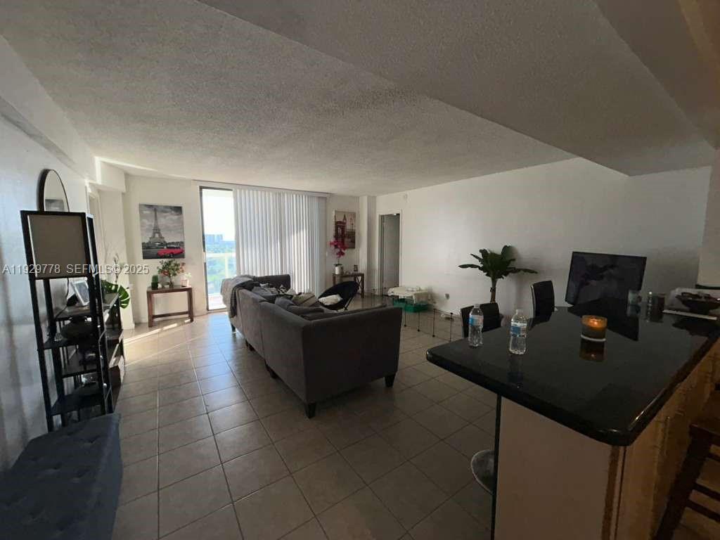 13499 Biscayne Boulevard, Unit 1206 North Miami, FL 33181 - Photo 7 of 20 a living room with furniture and a flat screen tv