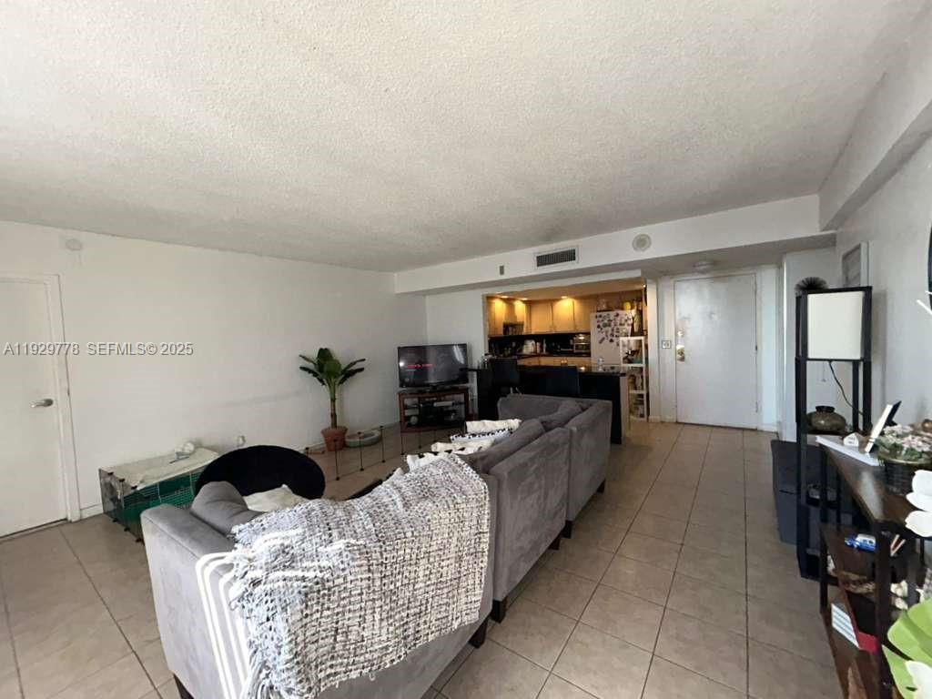 13499 Biscayne Boulevard, Unit 1206 North Miami, FL 33181 - Photo 9 of 20 a living room with furniture and a flat screen tv