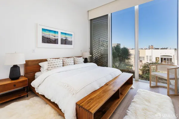 a bed sitting in a bedroom next to a larger window