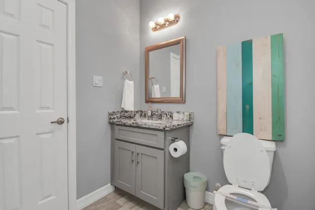 a bathroom with a toilet a sink and mirror