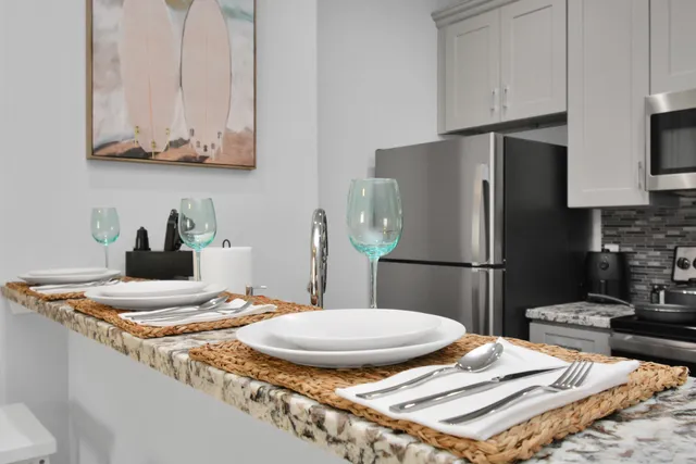 a kitchen with stainless steel appliances granite countertop a sink refrigerator and microwave