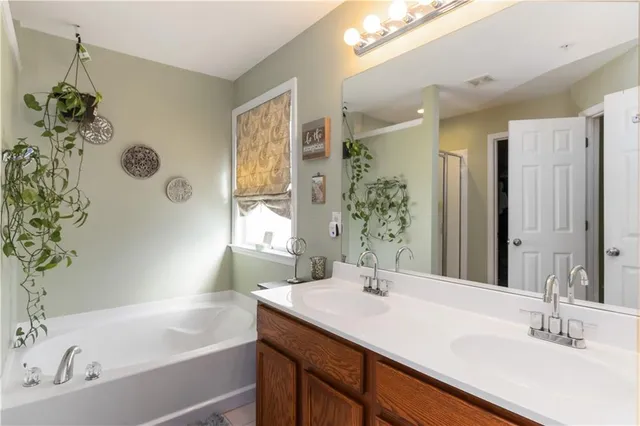 a bathroom with a granite countertop sink a mirror a and a bathtub