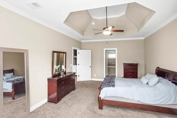 a bedroom with a bed and a large mirror on dresser
