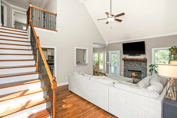 a living room with furniture a flat screen tv and a potted plant