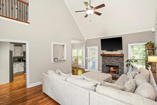 a kitchen with stainless steel appliances granite countertop a stove top oven a sink dishwasher a dining table and chairs with wooden floor