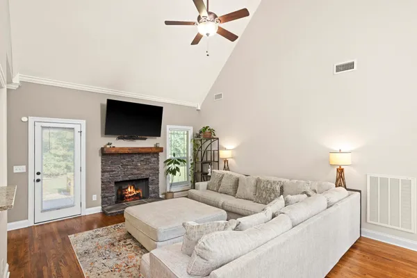 a kitchen with stainless steel appliances granite countertop a stove a sink dishwasher a dining table and chairs with wooden floor