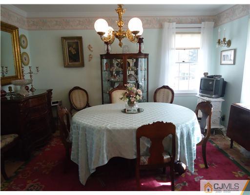 3 Ridge Lane Colonia, NJ 07067 - Photo 3 of 13 a dining room with a table chairs and a chandelier