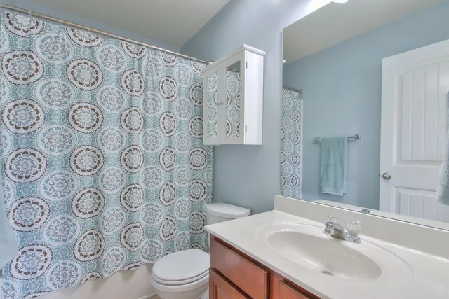 a bathroom with a sink and mirror with toilet
