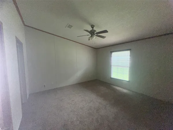 an empty room with a window and a fan