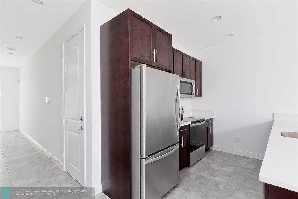 6965 Pines Circle, Unit 29 Pompano Beach, FL 33073 - Photo 14 of 27 a kitchen with stainless steel appliances granite countertop a refrigerator and a sink