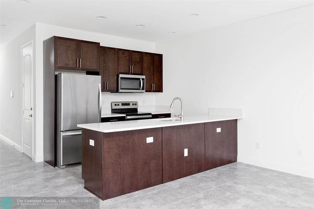 6965 Pines Circle, Unit 29 Pompano Beach, FL 33073 - Photo 6 of 27 a kitchen with stainless steel appliances a refrigerator and a stove top oven