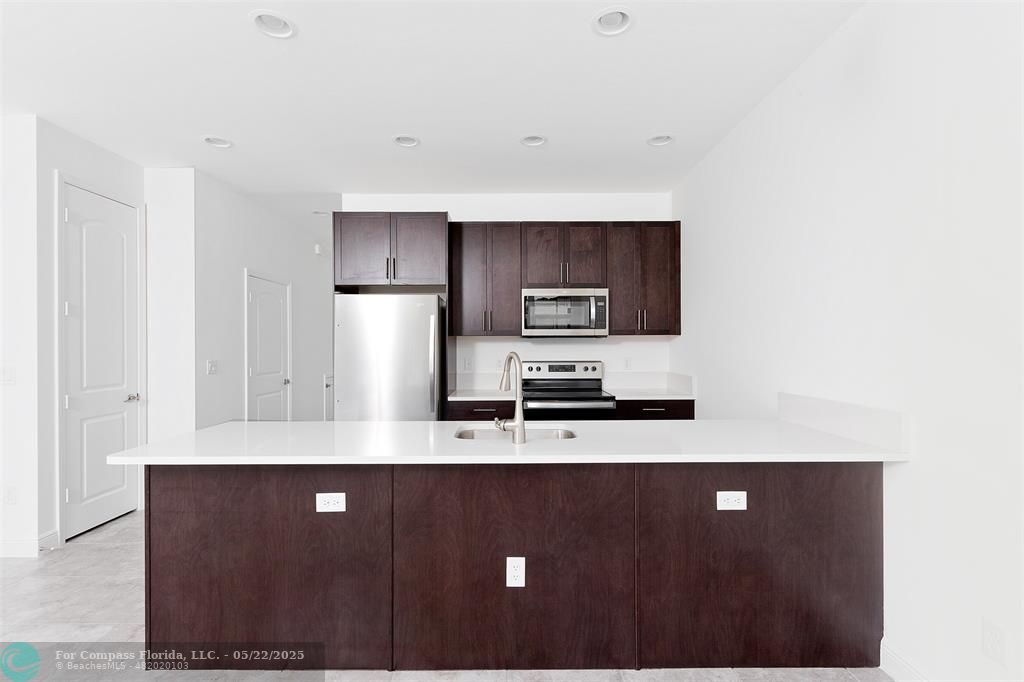 6965 Pines Circle, Unit 29 Pompano Beach, FL 33073 - Photo 7 of 27 a kitchen with stainless steel appliances a refrigerator and a stove