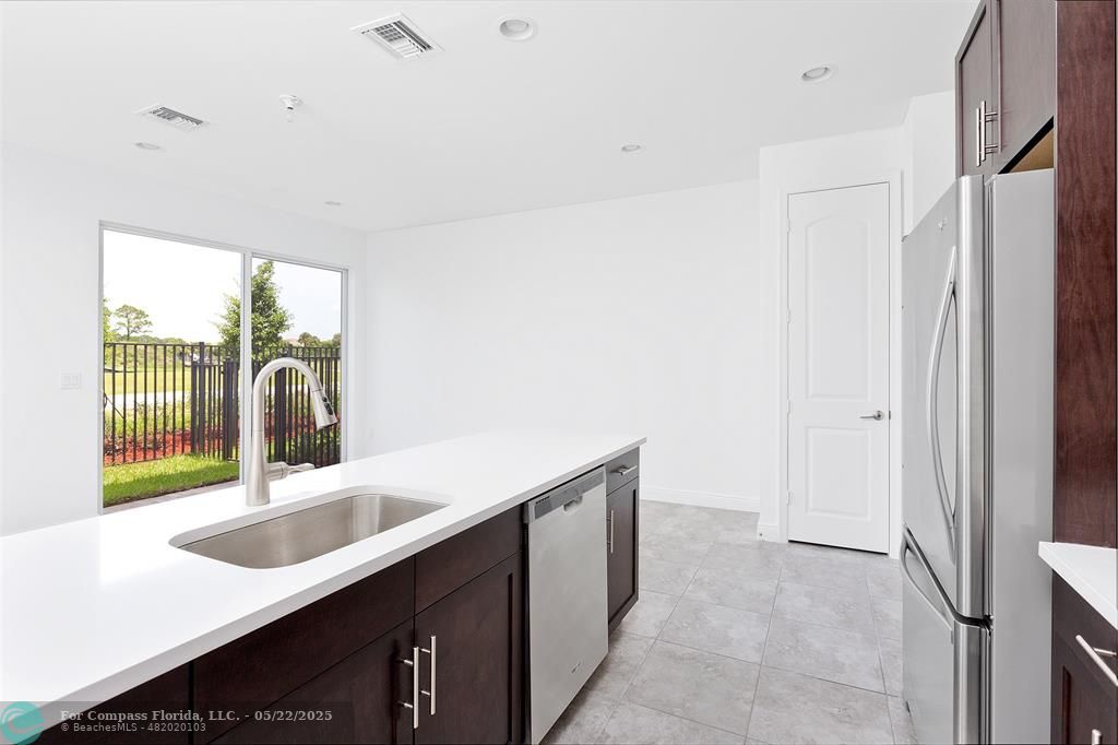 6965 Pines Circle, Unit 29 Pompano Beach, FL 33073 - Photo 9 of 27 a kitchen with a sink and a refrigerator