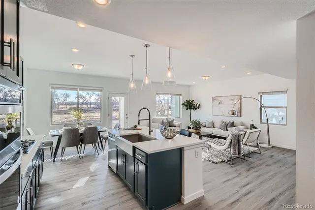 a very nice looking open dining room with kitchen island stainless steel appliances a table and chairs