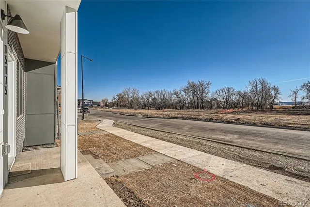 a view of a house with a door and wooden bench