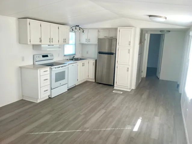 a kitchen with stainless steel appliances white cabinets and a refrigerator