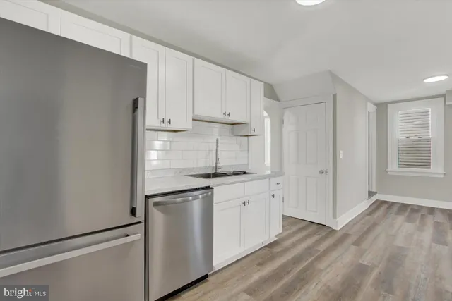 a kitchen with granite countertop white cabinets and white appliances