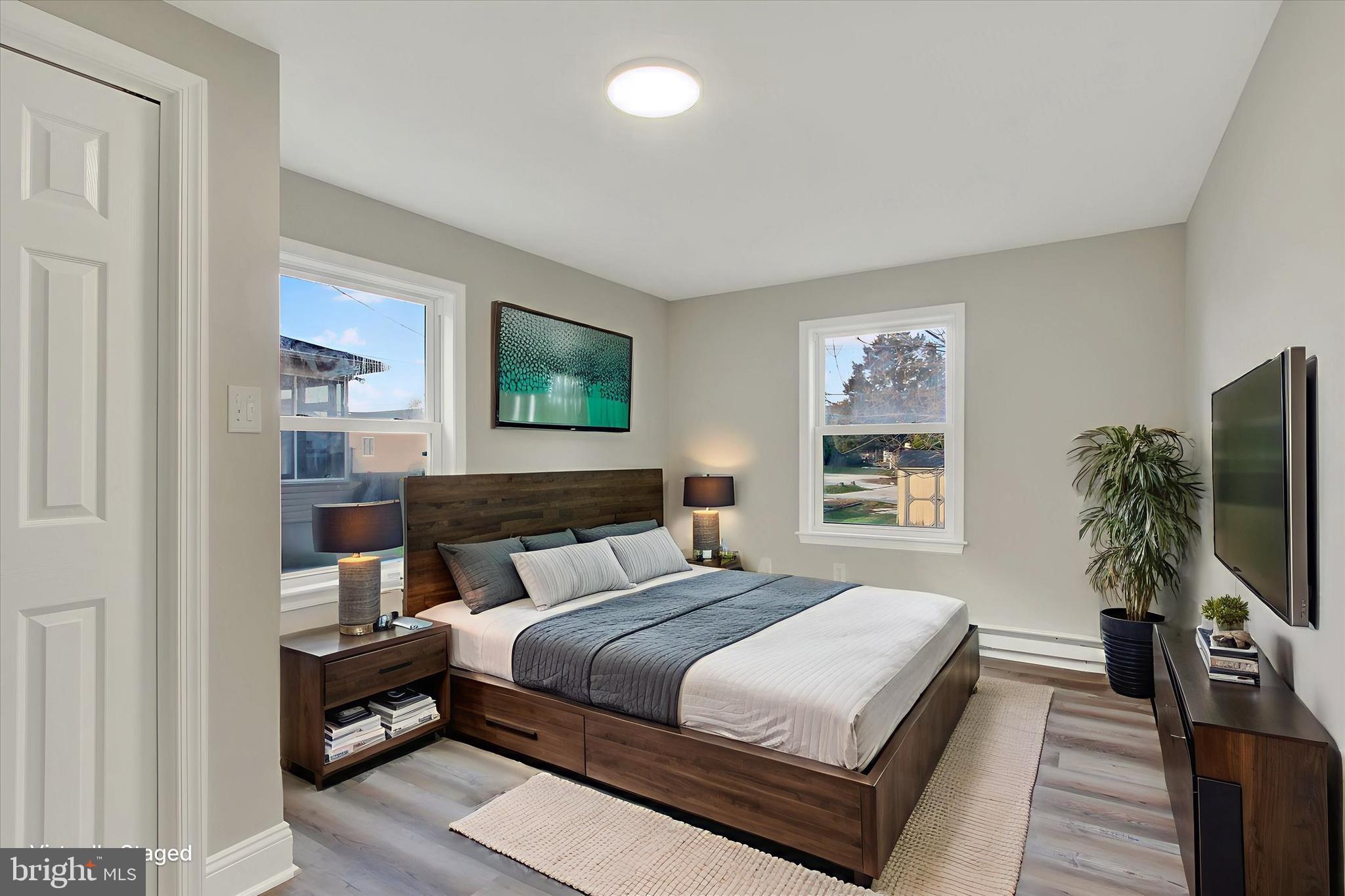 632 East Walnut Street Hanover, PA 17331 - Photo 15 of 30 a bedroom with a large bed a flat tv screen and a potted plant