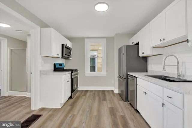 a kitchen with a sink a refrigerator and cabinets