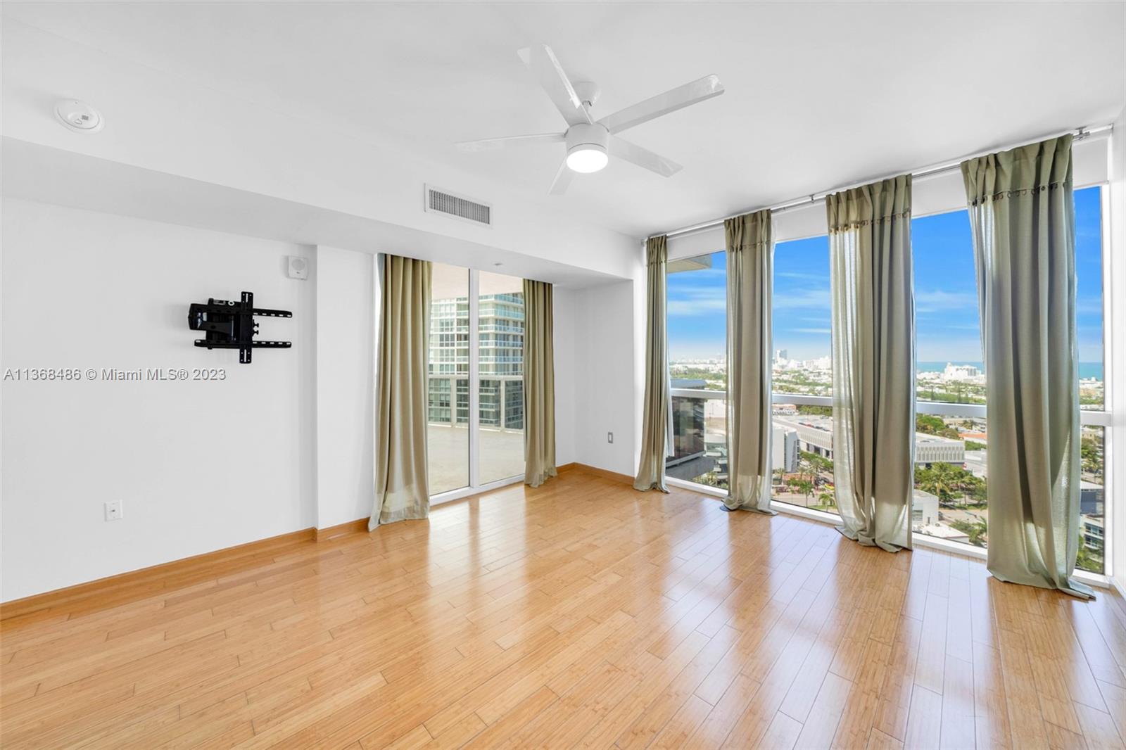 400 Alton Road, Unit 2002 Miami Beach, FL 33139 - Photo 16 of 25 a view of an empty room with a window and wooden floor