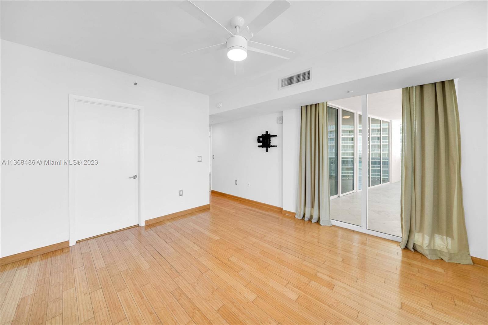 400 Alton Road, Unit 2002 Miami Beach, FL 33139 - Photo 20 of 25 an empty room with wooden floor and windows