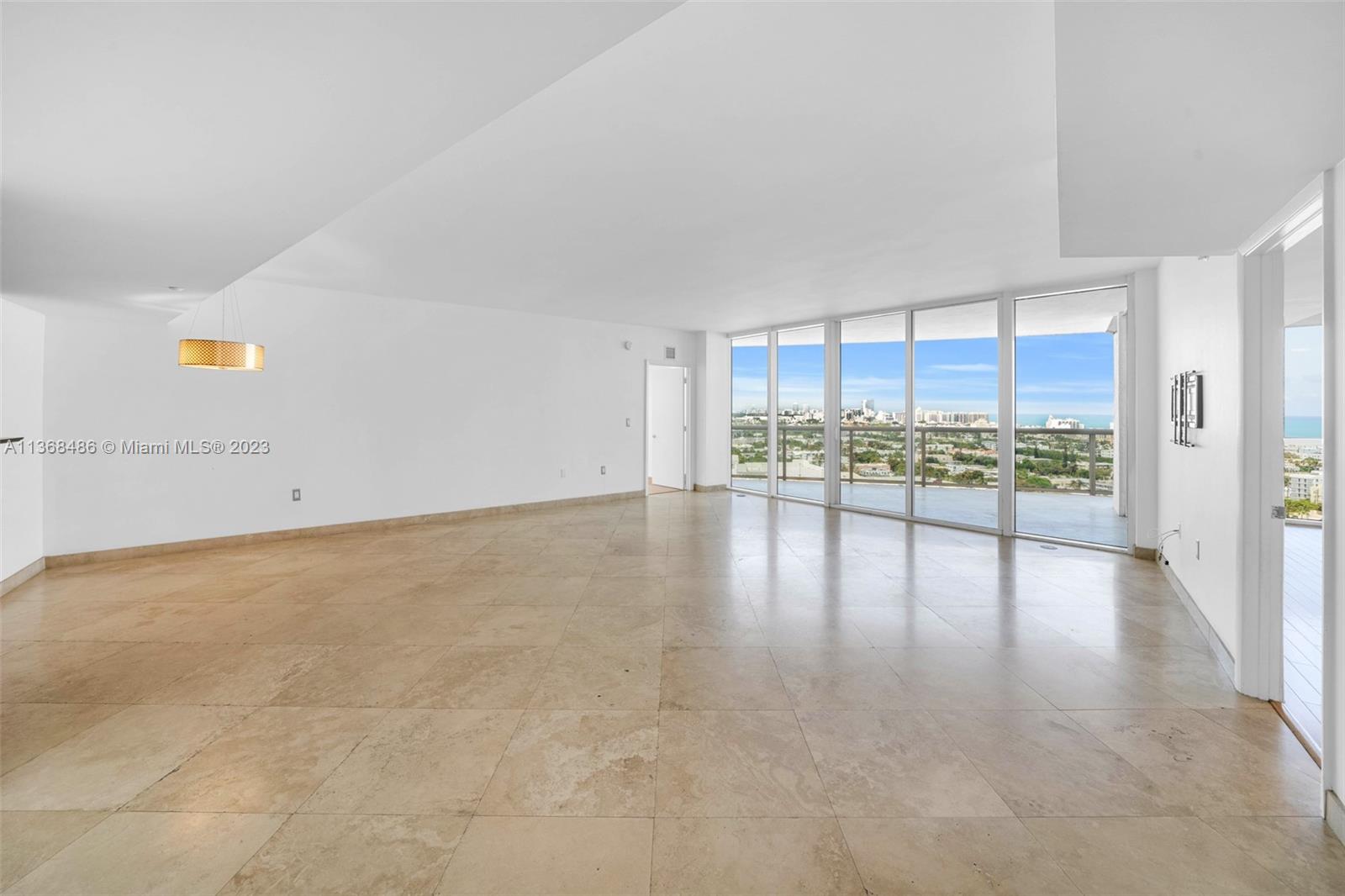 400 Alton Road, Unit 2002 Miami Beach, FL 33139 - Photo 3 of 25 a view of a kitchen with a floor to ceiling window and an empty room