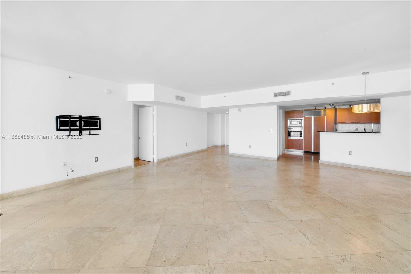 400 Alton Road, Unit 2002 Miami Beach, FL 33139 - Photo 6 of 25 an empty room with windows and refrigerator