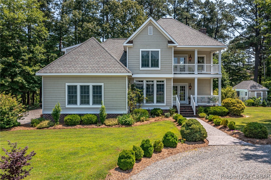 3215 Weems Road Weems, VA 22576 - Photo 6 of 50 a front view of a house with a garden and porch