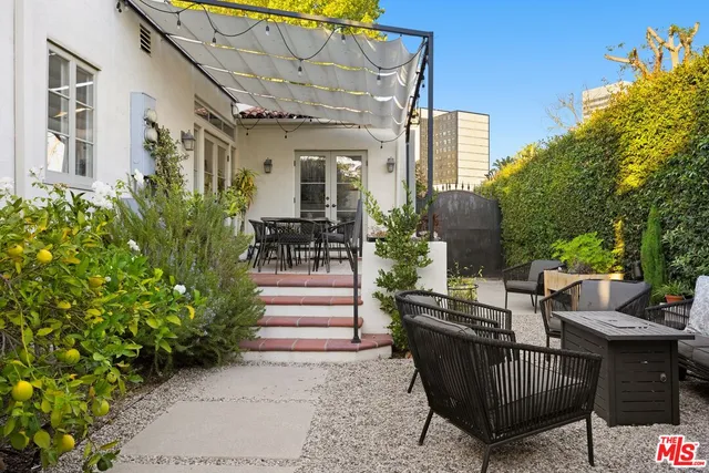 a view of a patio with couches table and chairs and potted plants